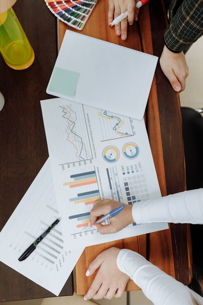 Services Top view of business team analyzing charts and data on paper for strategic planning.